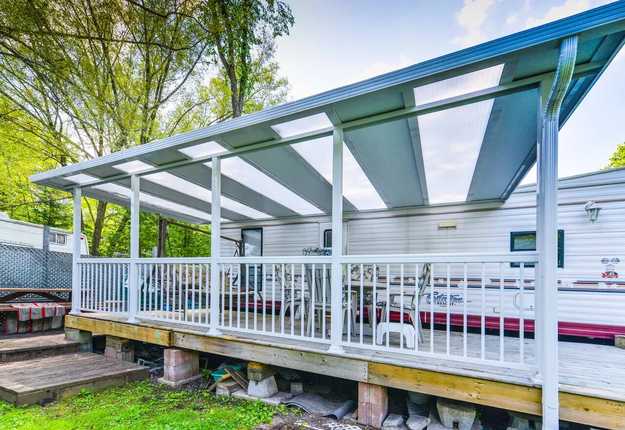 White hybrid patio cover with acrylic panels over a mobile home deck.